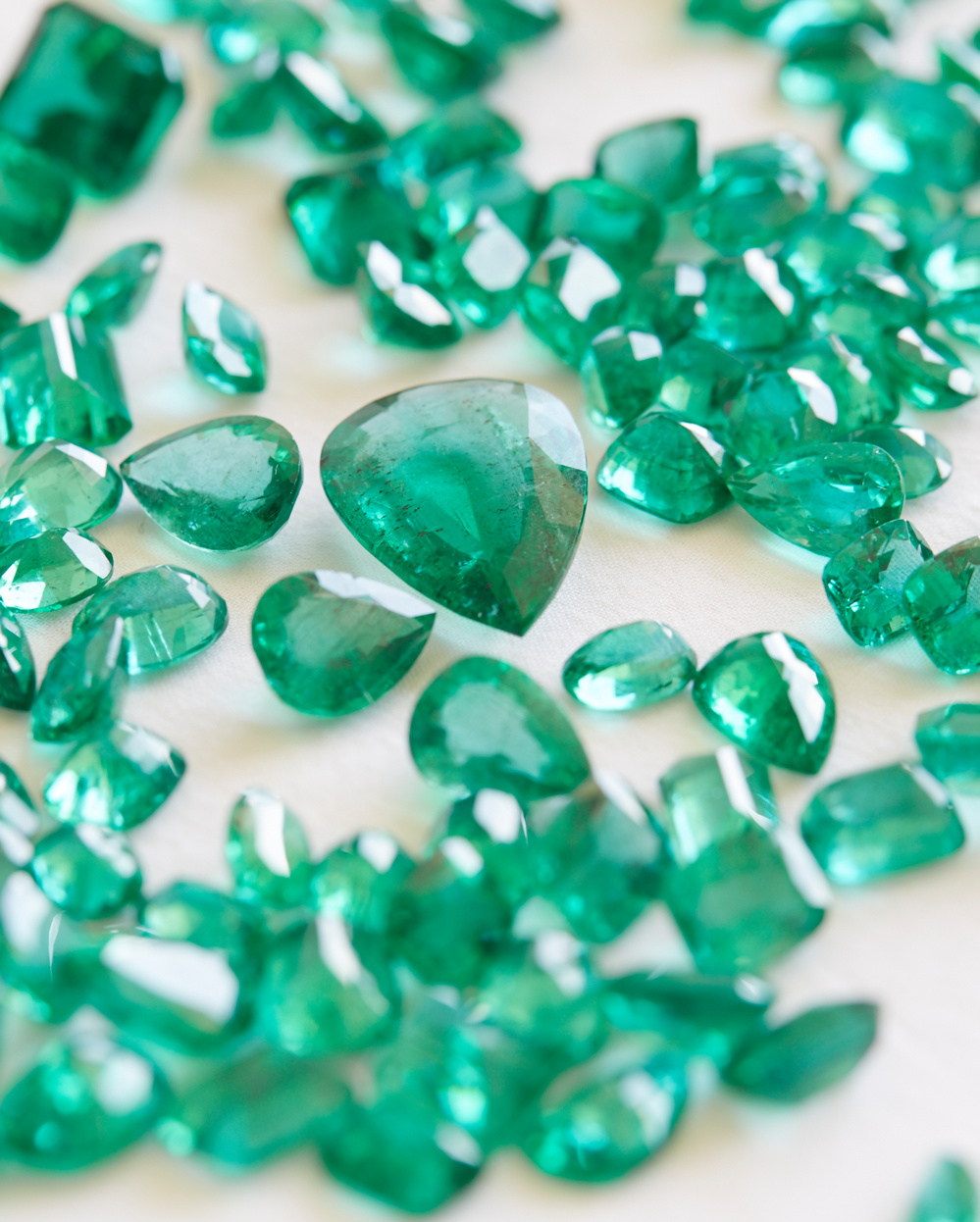 A close up of emerald stones laid out on a table. 