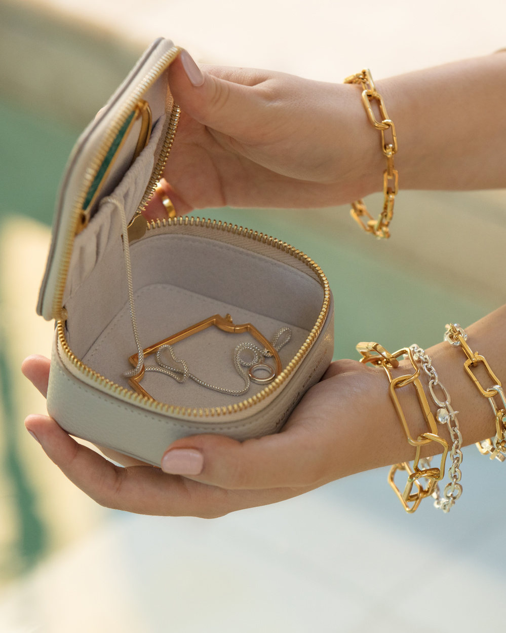 Model holding open a Monica Vinader jewellery box, wearing a mix of gold and silver pieces