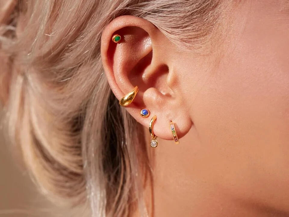 mix and match lobe and cartilage piercings on one ear for an eclectic look