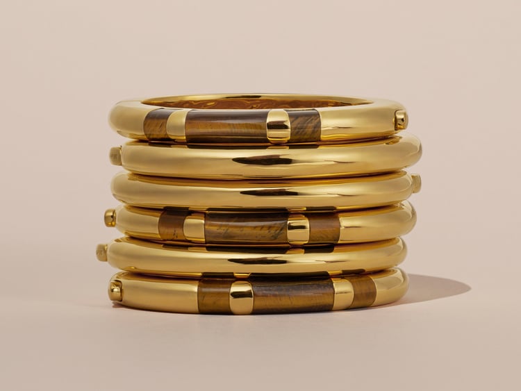 Chunky bangles, some with blocks of tiger's eye, stacked